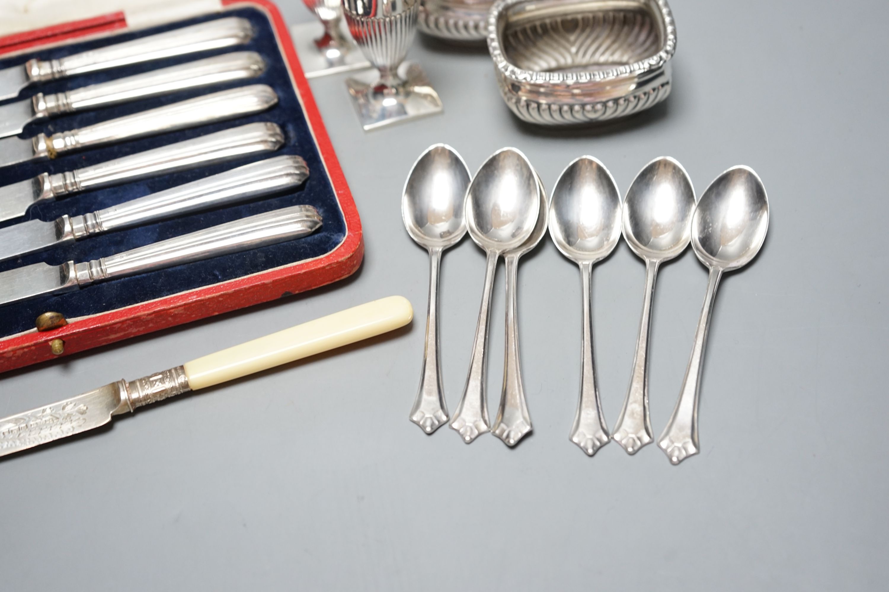 A pair of Victorian silver pepperettes, a pair of later silver salts, six silver teaspoons, a silver dessert knife and a cased set of silver handled tea knives.